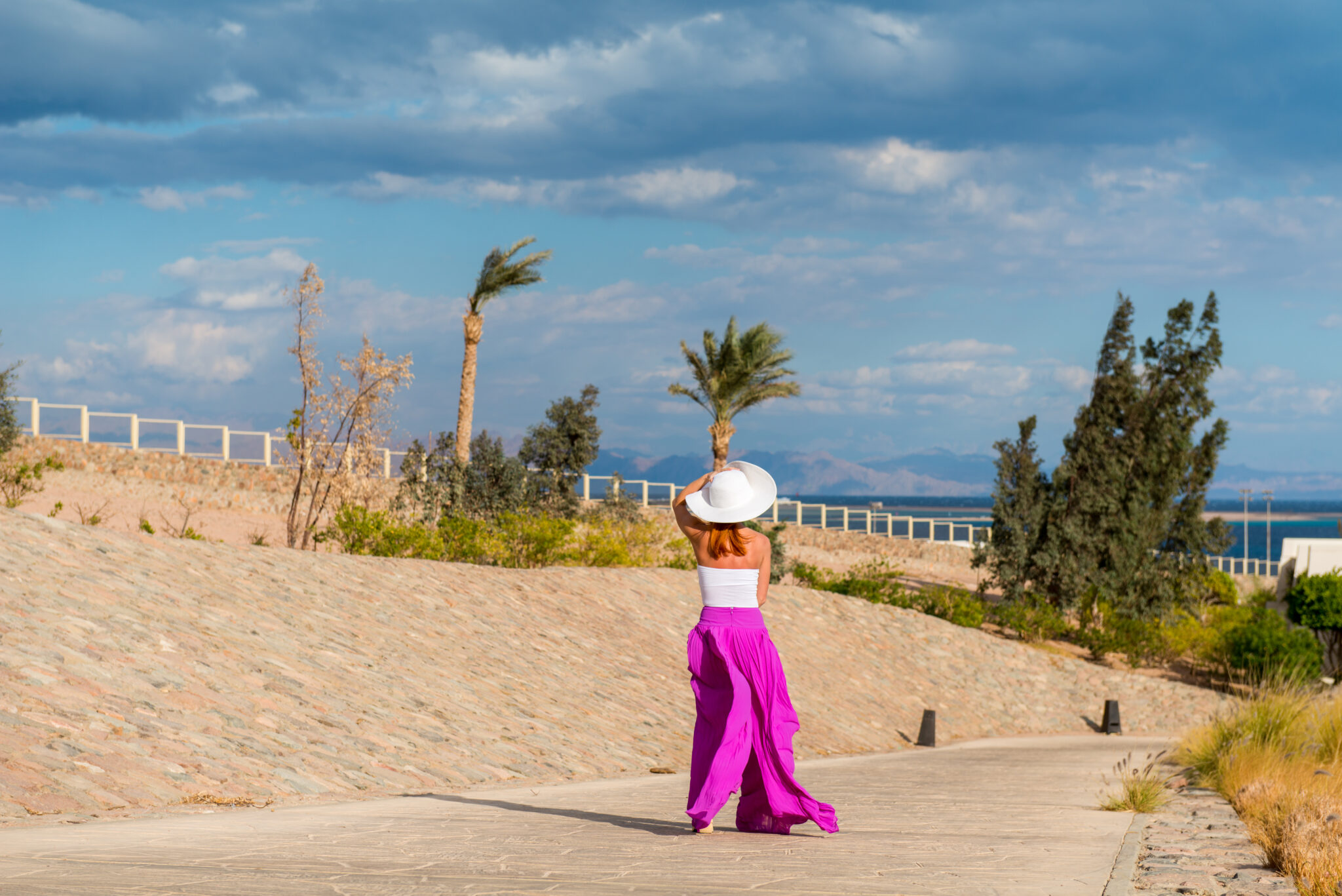 Photo of  beautiful young woman in a hat at sea resort